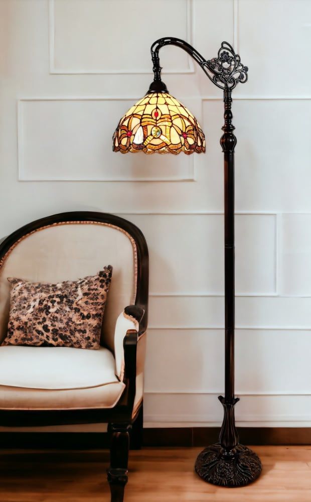 a lamp sitting on top of a wooden floor next to a chair with a pillow