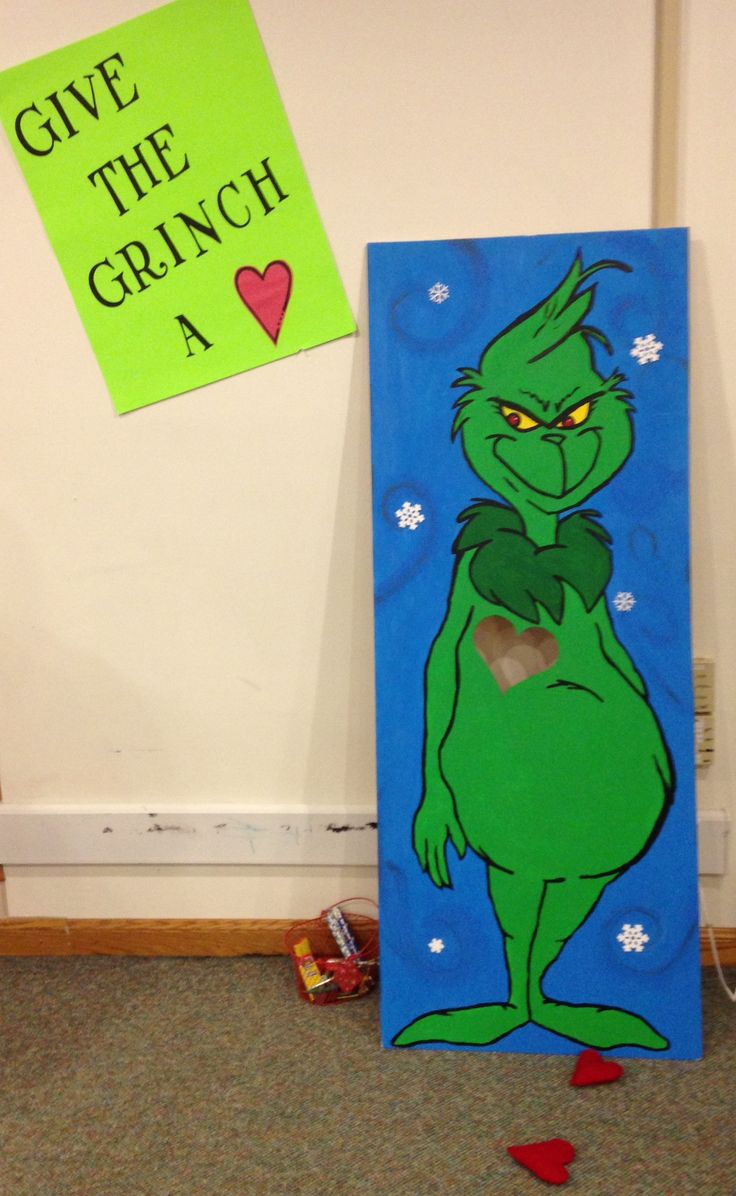 the grinch is standing in front of a green sign