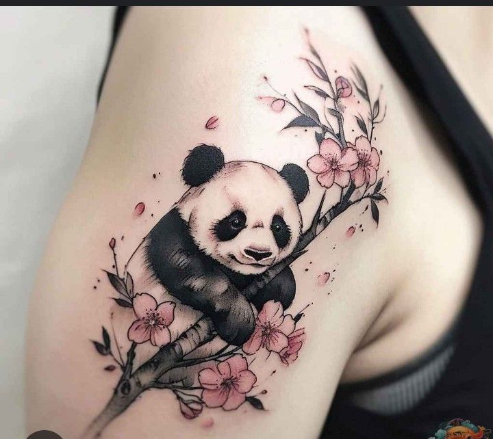 a panda bear sitting on top of a tree branch with pink flowers around its neck