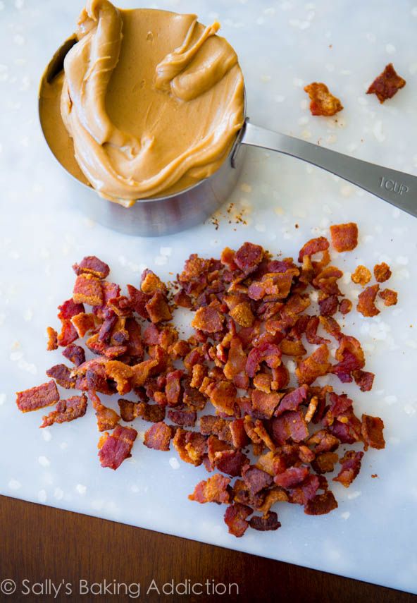 chopped bacon on a cutting board next to a bowl of peanut butter and a spoon