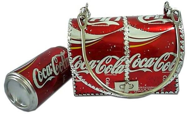 a coca - cola can purse is sitting on top of a bag with chains hanging from it