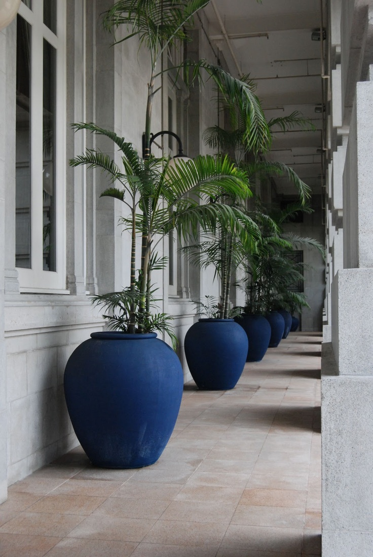 three large blue planters sitting on the side of a building next to each other