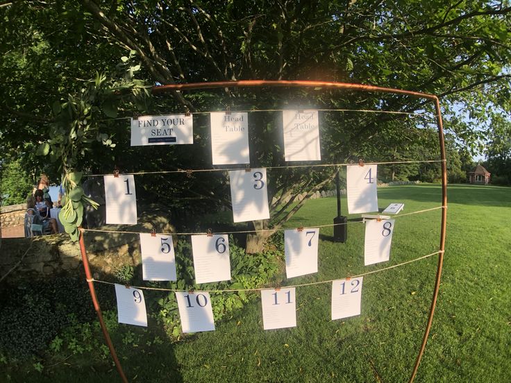 a group of people standing in front of a tree with lots of white paper on it