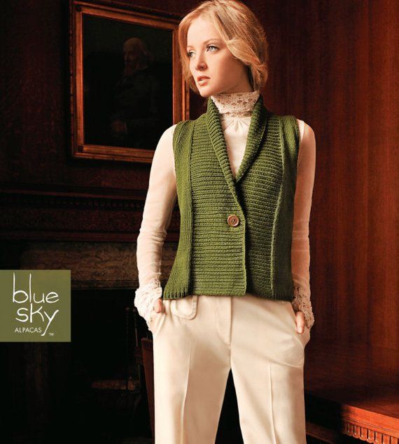 a mannequin wearing a green vest and white pants in front of a fireplace