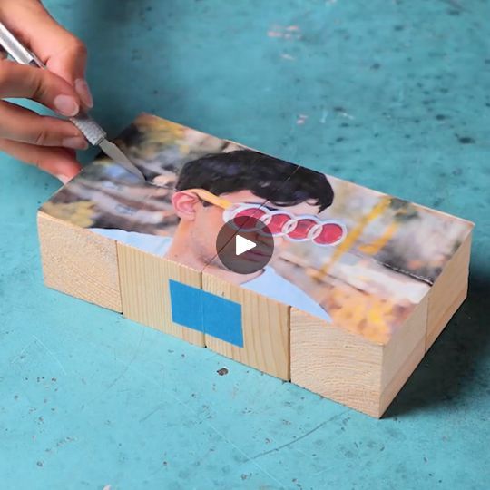 a person is cutting out a photo with a toothbrush on top of a wooden box