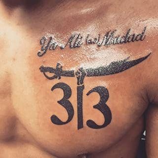 a man with a tattoo on his chest has the number thirteen and is holding a knife