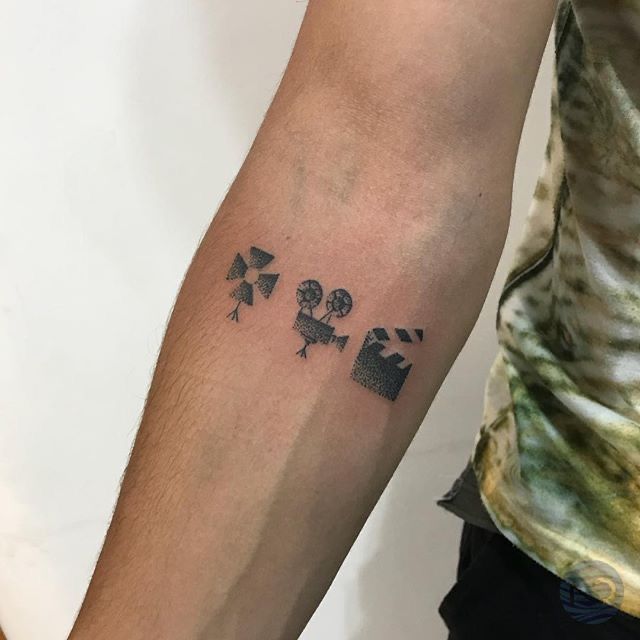 a man with a tattoo on his arm that has four dices and hearts in it