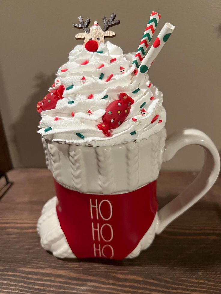 a cup with whipped cream and candy canes in it