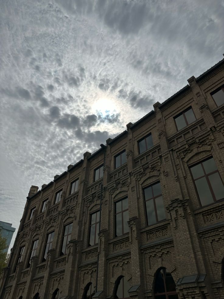 an old building with many windows under a cloudy sky