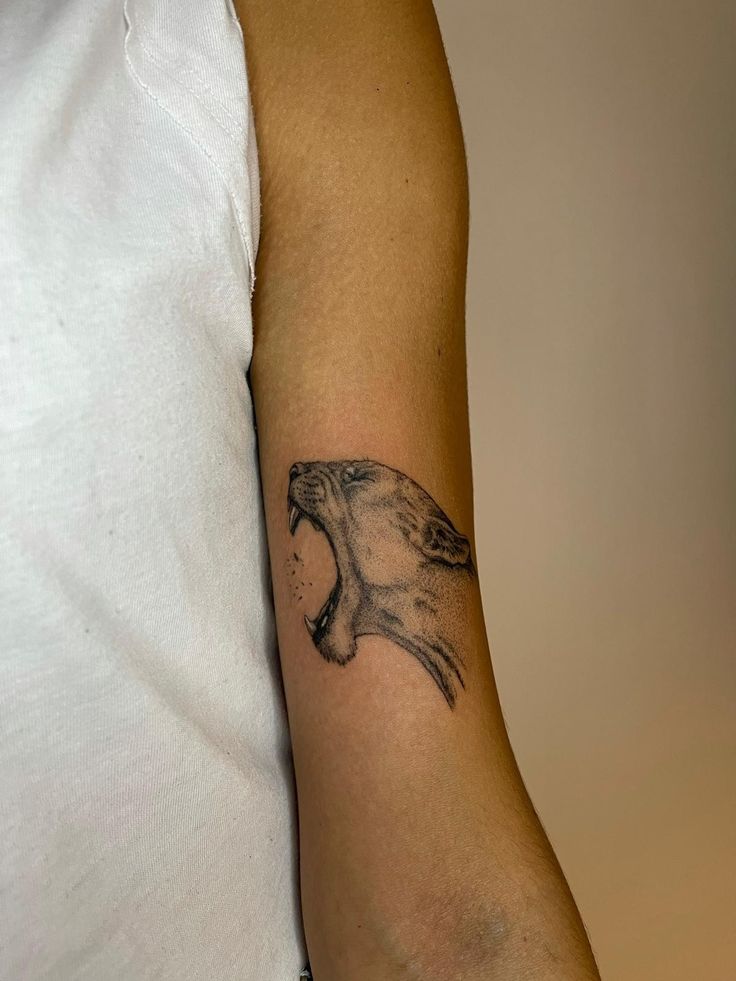 a man's arm with a tattoo of a bird on it and an open mouth