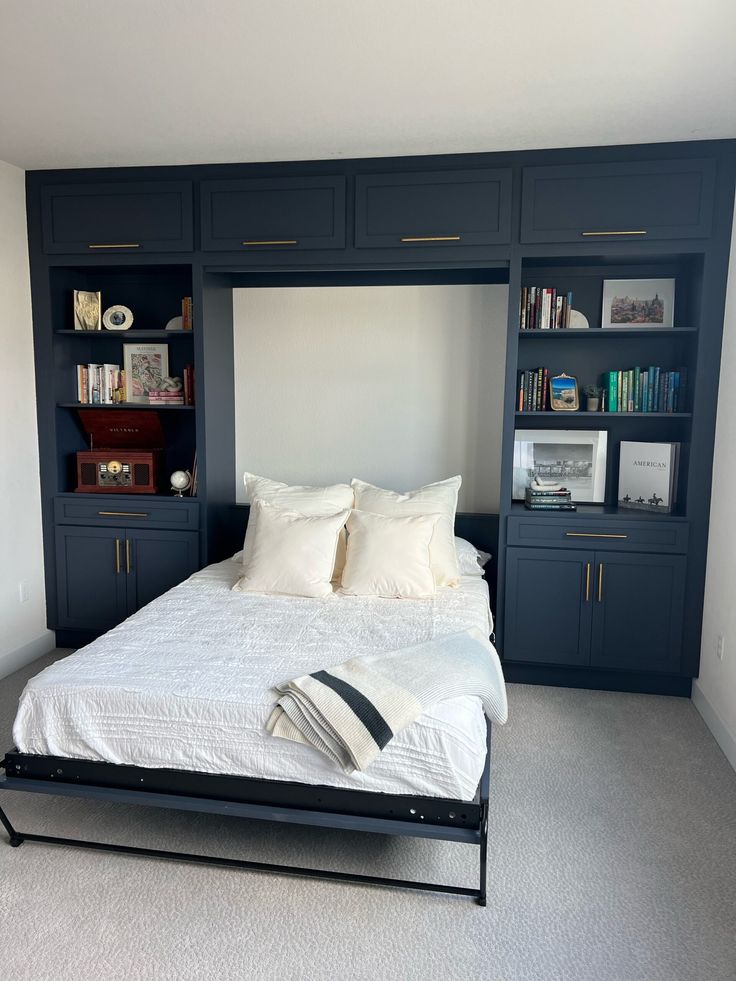 a large bed sitting in the middle of a bedroom next to a book shelf filled with books