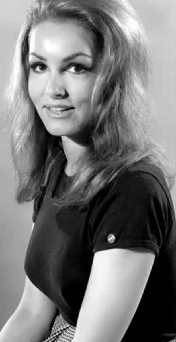 an old black and white photo of a woman with long hair wearing a t - shirt