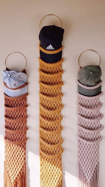 three crocheted wall hangings with hats on them