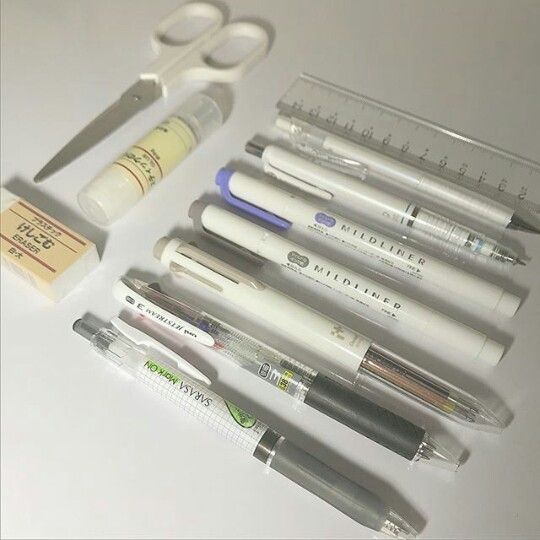 several pens, scissors and other medical supplies are arranged on a table