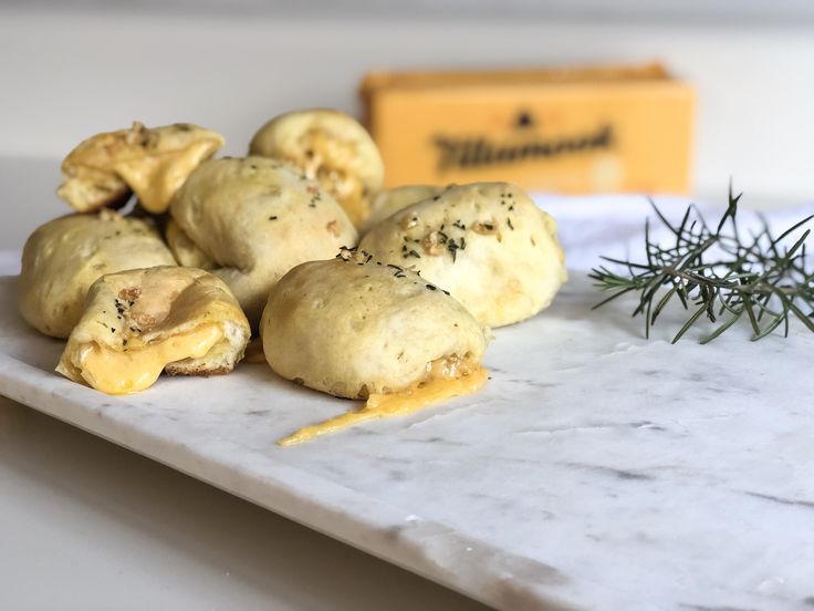 several pastries on a marble platter with rosemary sprig