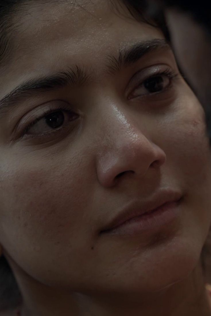 a close up of a woman with freckles on her face looking at the camera