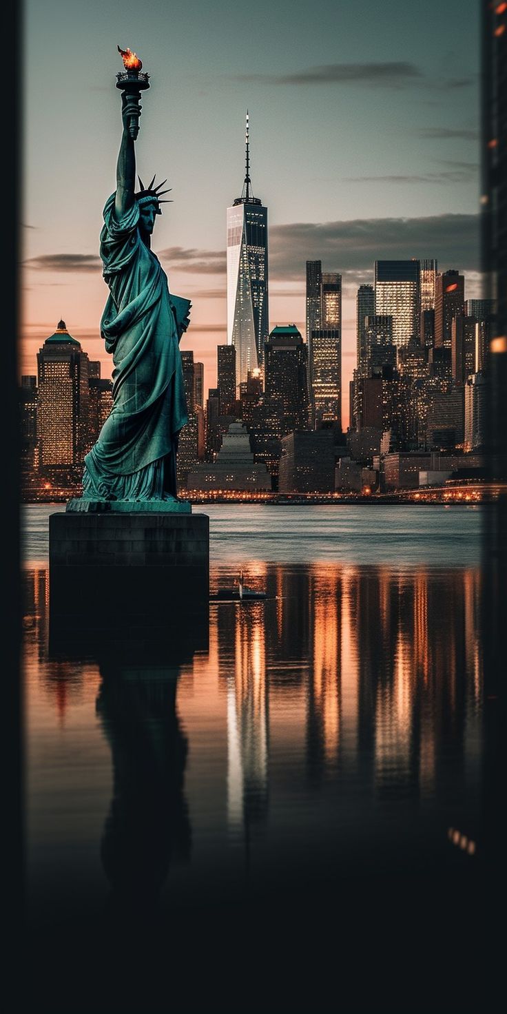 the statue of liberty in new york city, ny at sunset with its reflection on the water