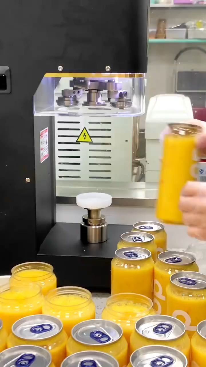 a person is holding a glass in front of some orange juices on a table