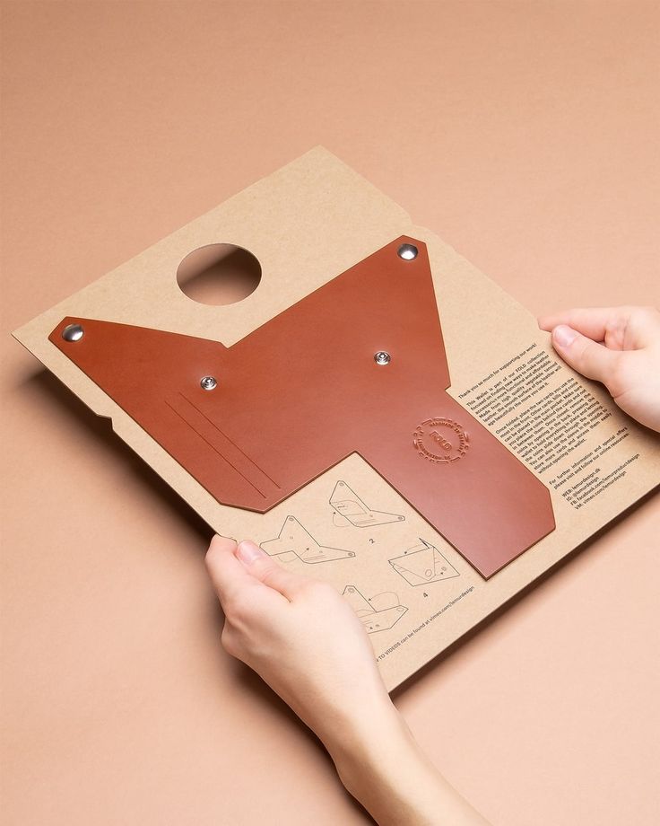 a person is holding a piece of cardboard with holes in it and the paper has been cut out