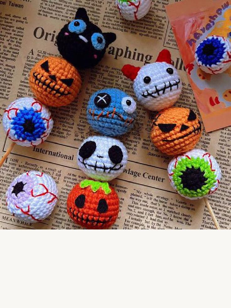 there are many crocheted pumpkins on the table with toothpicks in them