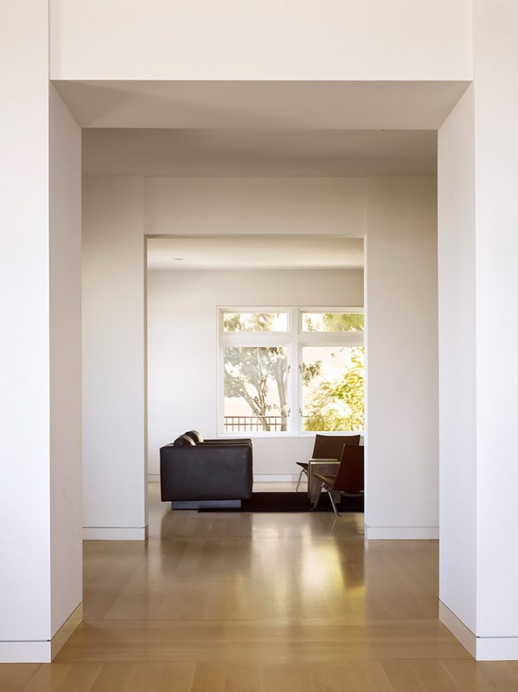 an empty living room with white walls and wood floors