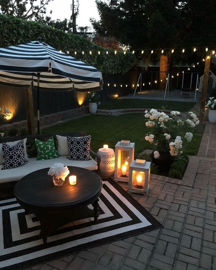 an outdoor seating area with lit candles and flowers