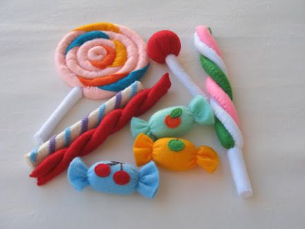 there are several different types of candy on the white tablecloth, including lollipops and candies