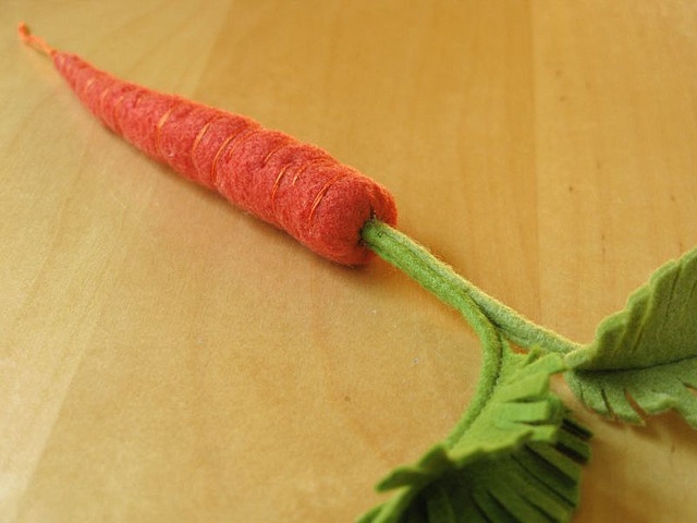 a toy carrot laying on top of a wooden table