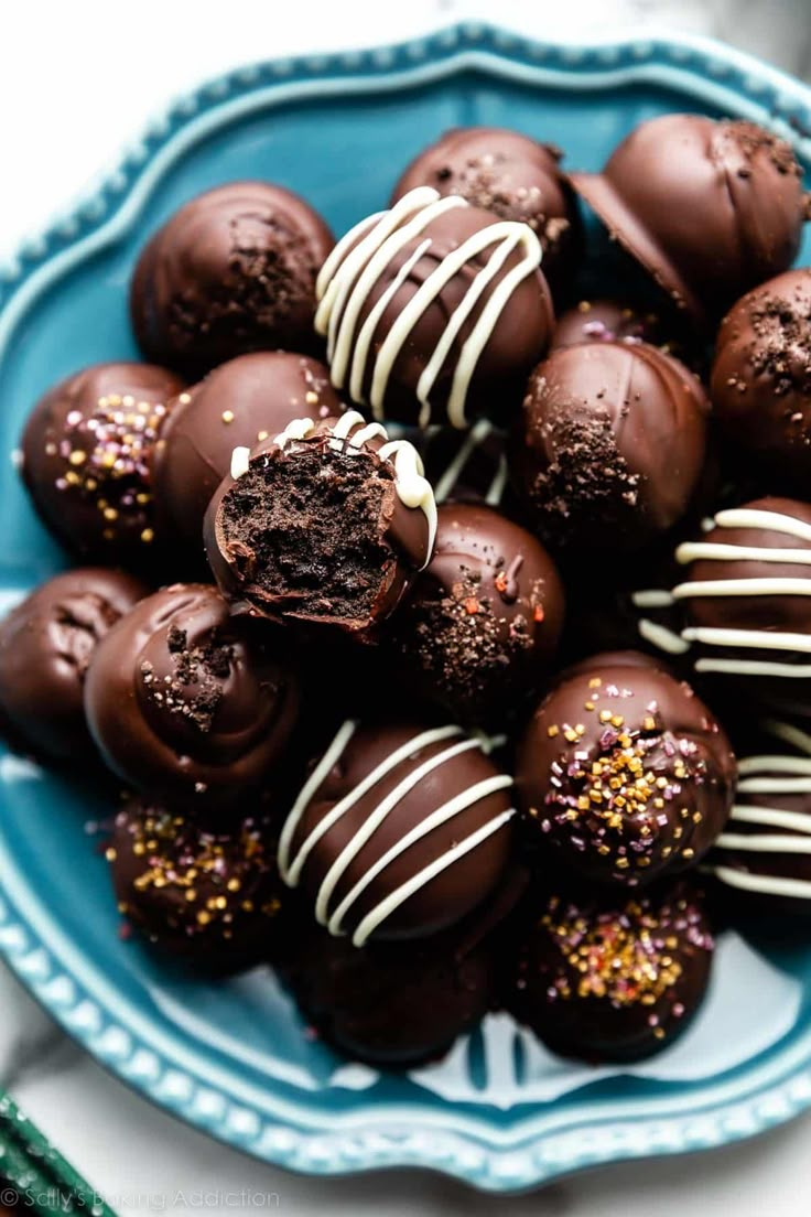 chocolate covered candies on a blue plate with sprinkles and white icing