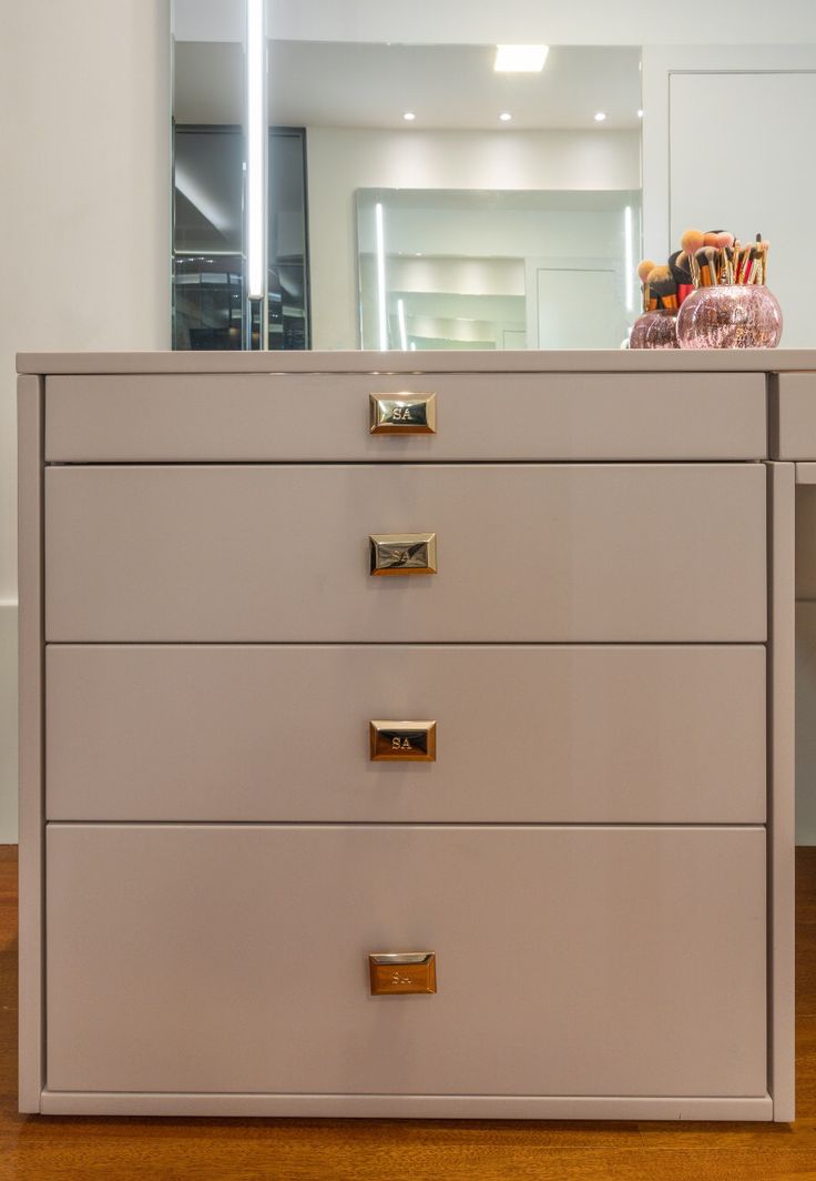 a dresser with drawers and a mirror in the background