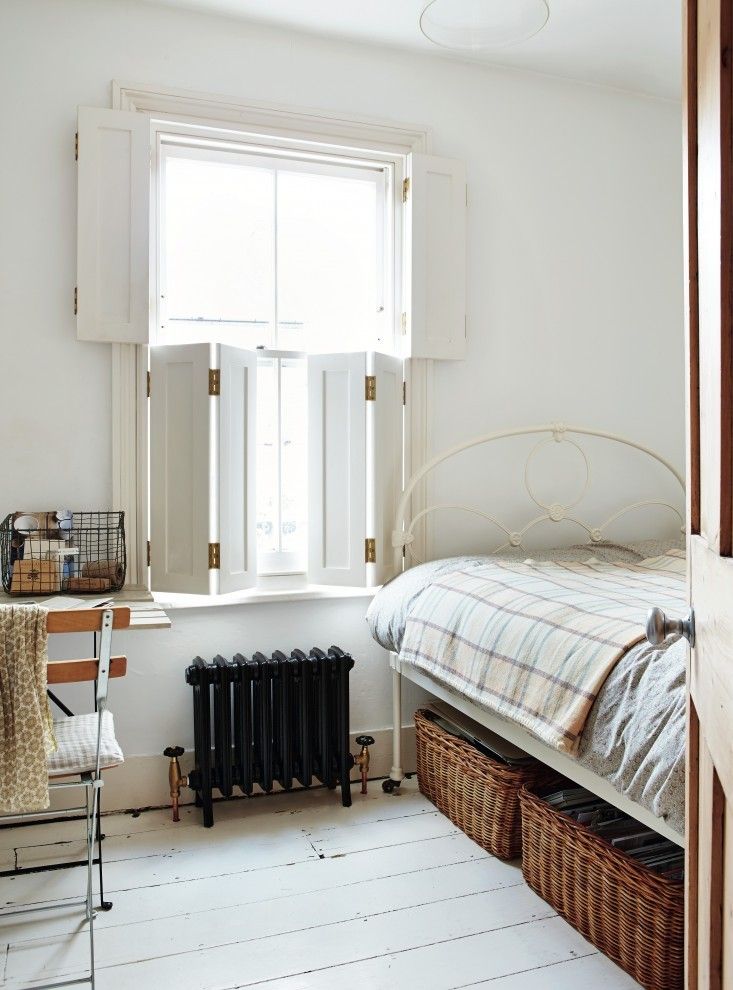 a bedroom with a bed, desk and window