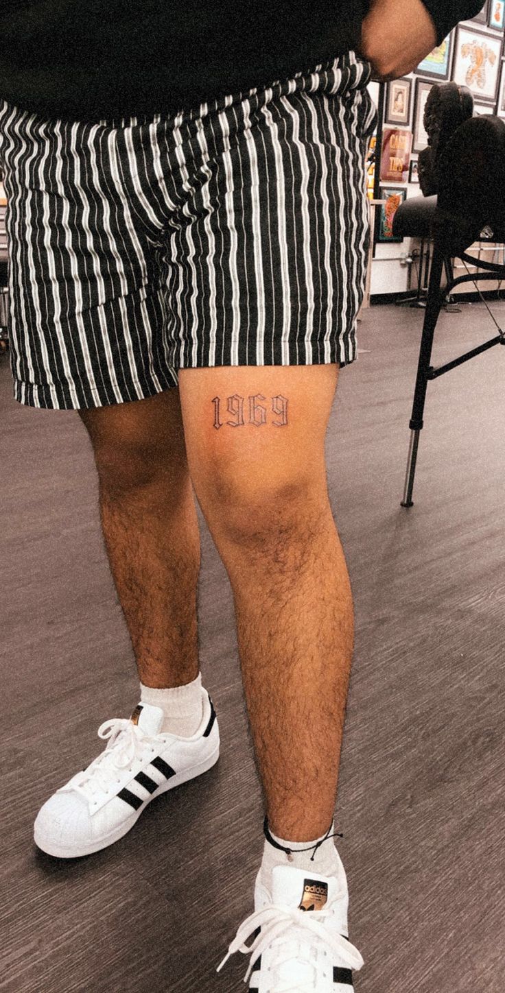 a man wearing shorts with the word love tattooed on his leg