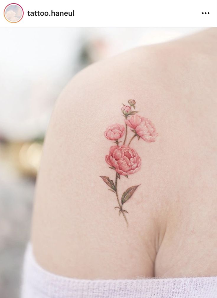 the back of a woman's shoulder with pink flowers on it