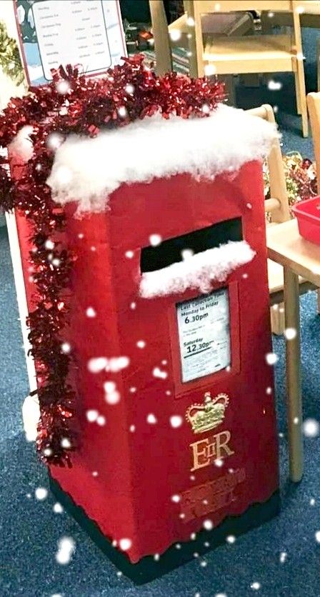 a red mailbox covered in snow sitting on top of a blue carpeted floor