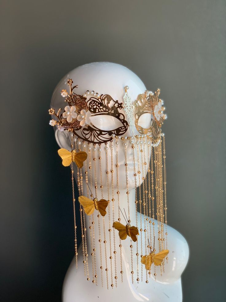 This elegant golden metal masquerade mask features dangling butterflies with floral notes and pearls. The mask is made out of comfortable and lightweight metal, great for long time wear! I N C L U D E D Mask comes with matching ribbons. S H I P P I N G -  Processed same day or within 24 hours.  1-2 day guaranteed delivery, add item to cart, click shipping tab for rates.  Pls leave a check out note with your need date & contact number  Msg for delivery time frames (Include your state/country) S I