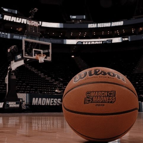 a basketball sitting on top of a hard wood floor in front of a basket ball