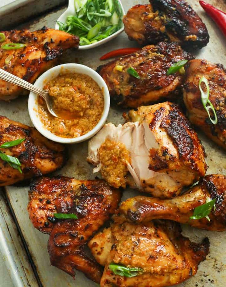 grilled chicken and vegetables on a tray with dipping sauce