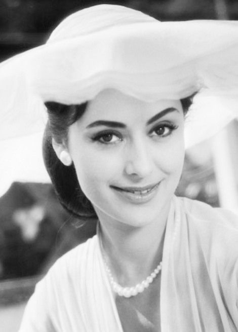 black and white photograph of a woman wearing a hat with veil on it's head