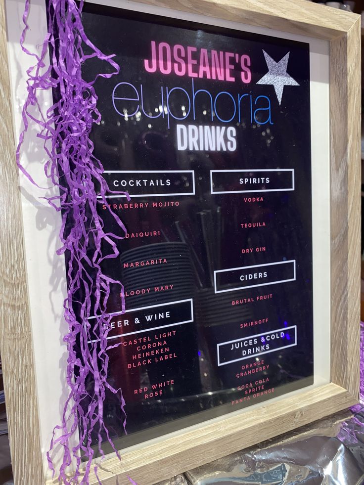 a sign with purple streamers hanging from it's sides in front of a window