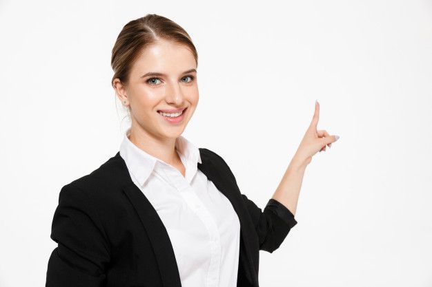 a woman in a business suit pointing to the left with her finger up and smiling