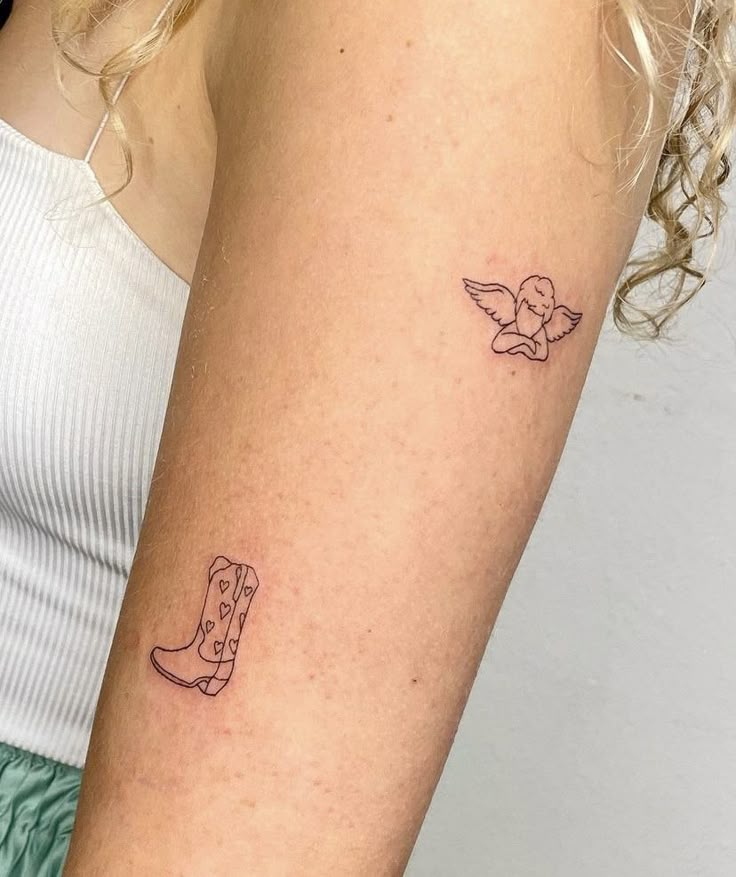 a woman's arm with two tattoos on it, one has a cowboy boot and the other has a bird