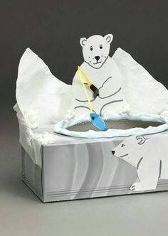 a polar bear is playing with a toothbrush in an ice box that's filled with tissue paper