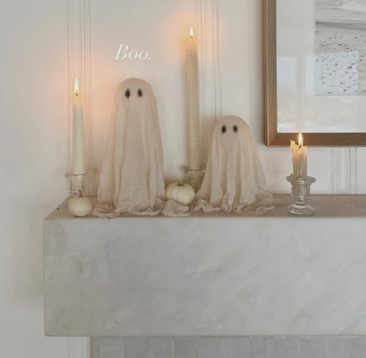 two ghost candles sitting on top of a mantle