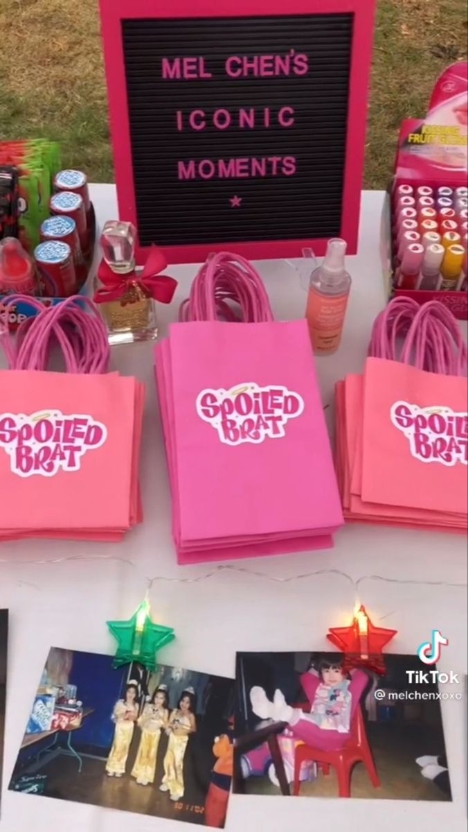 some pink bags are sitting on a table with pictures and candles in front of them