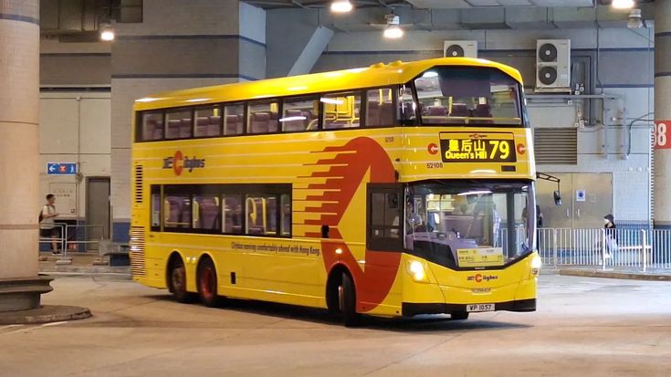 a yellow double decker bus parked in a parking garage