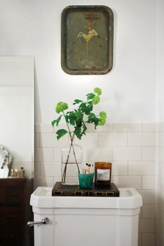 a white toilet sitting in a bathroom next to a painting