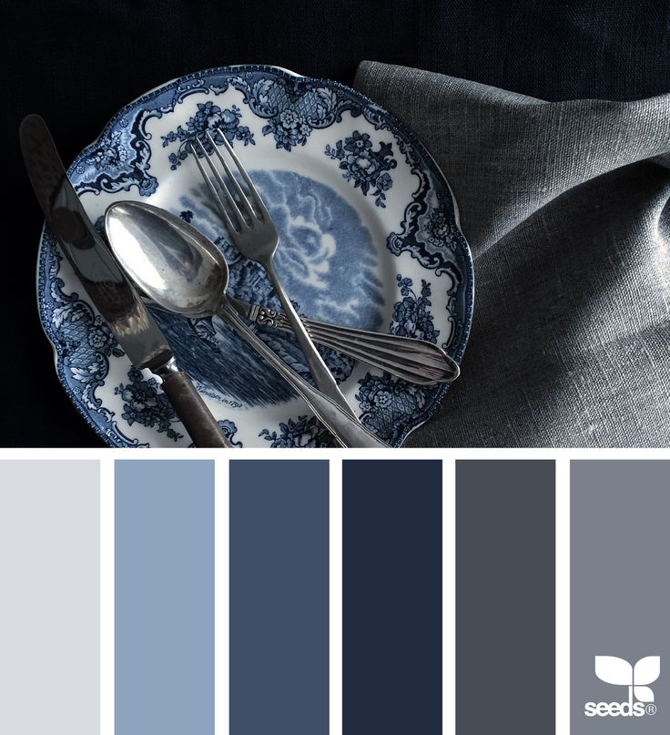 a blue and white plate with silverware on it, along with gray napkins