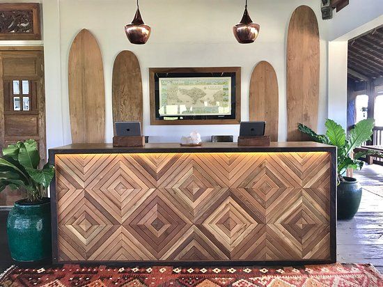 the front desk is made out of wood and has round lights hanging from it's ceiling