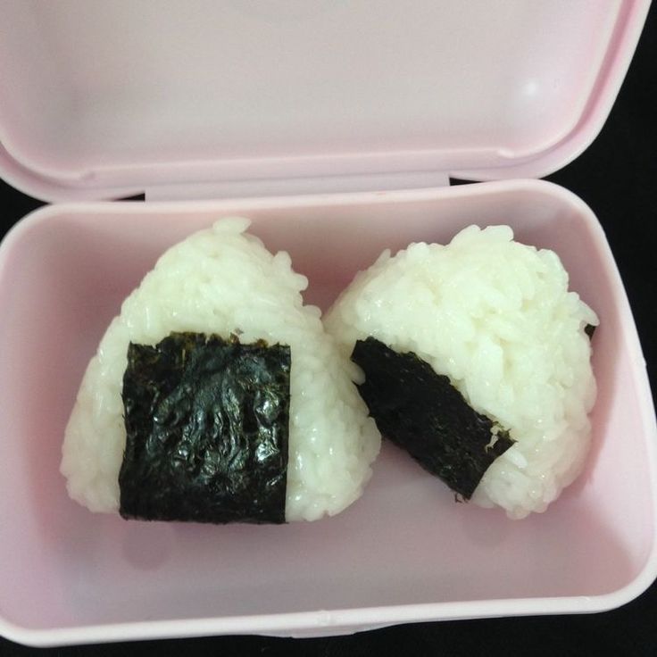 two pieces of sushi in a pink plastic container