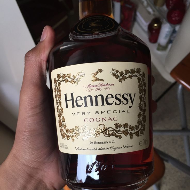 a hand holding a bottle of hennessy very special cognac wine in it's palm